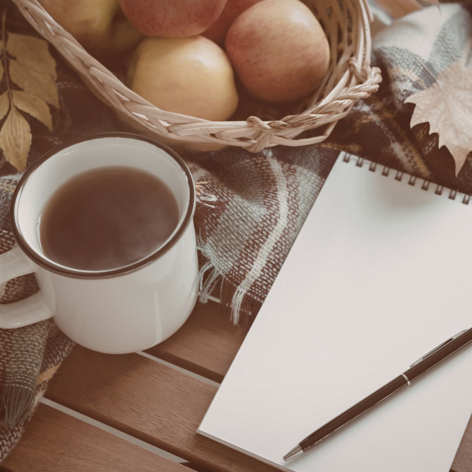 a notebook, tea and apples