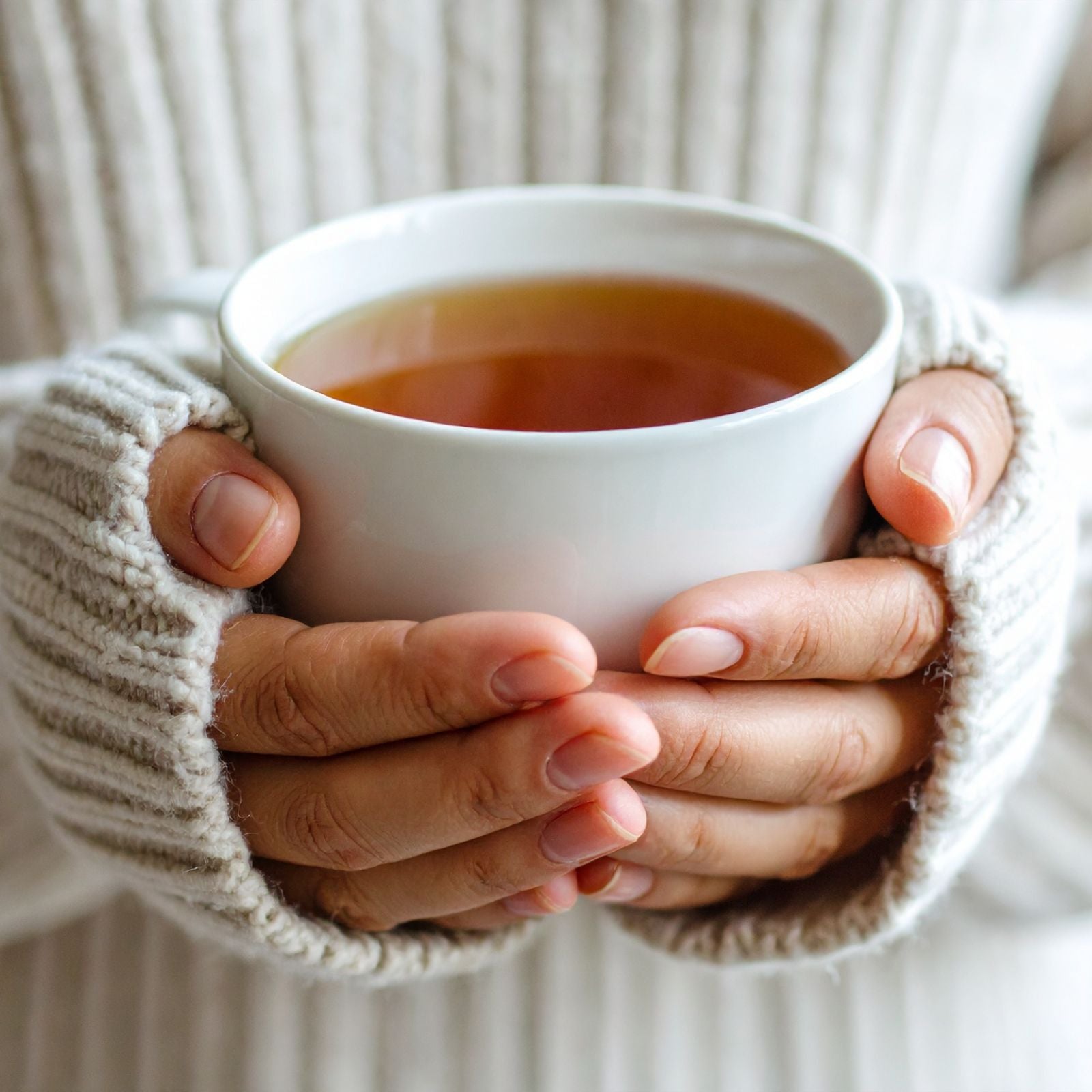 woman is holding a tea cup