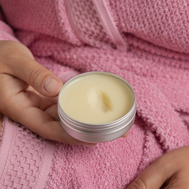 a woman is holding a body butter